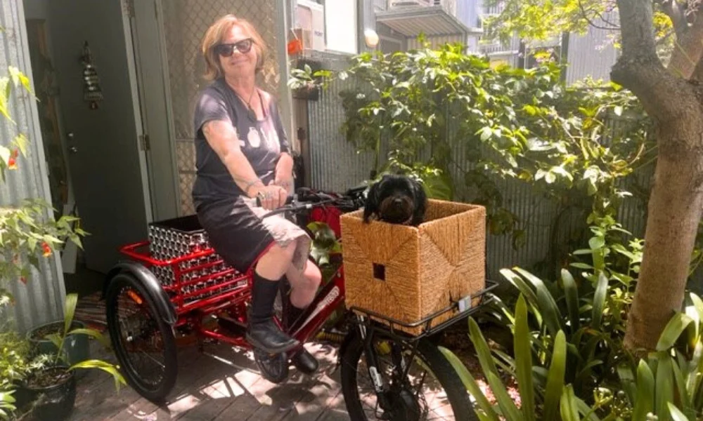 a woman on a trike with a dog basket