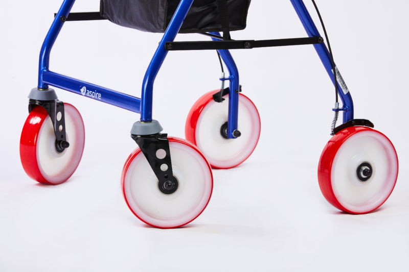 Close-up of the red and white wheels on a blue 'aspire' rollator, highlighting the sturdy metal frame and the secure attachment of the wheels.