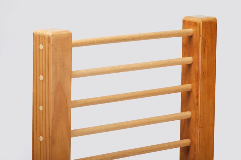 Close-up view of a wooden ladder frame with smooth, rounded rungs and side rails. The ladder is made of light-coloured wood with visible grain, showcasing a simple and sturdy design."