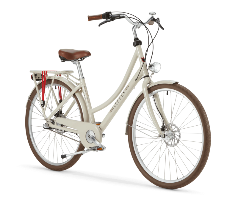 A beige cruiser bicycle with a brown seat and brown handle grips. The bike has a rear cargo rack with red straps, a front light, and a step-through frame design. The brand name 'LEKKER' is displayed on the frame. The bike features large brown tires with white rims and a chain guard for added protection.
